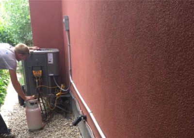 Electrician servicing an outdoor air-conditioning unit